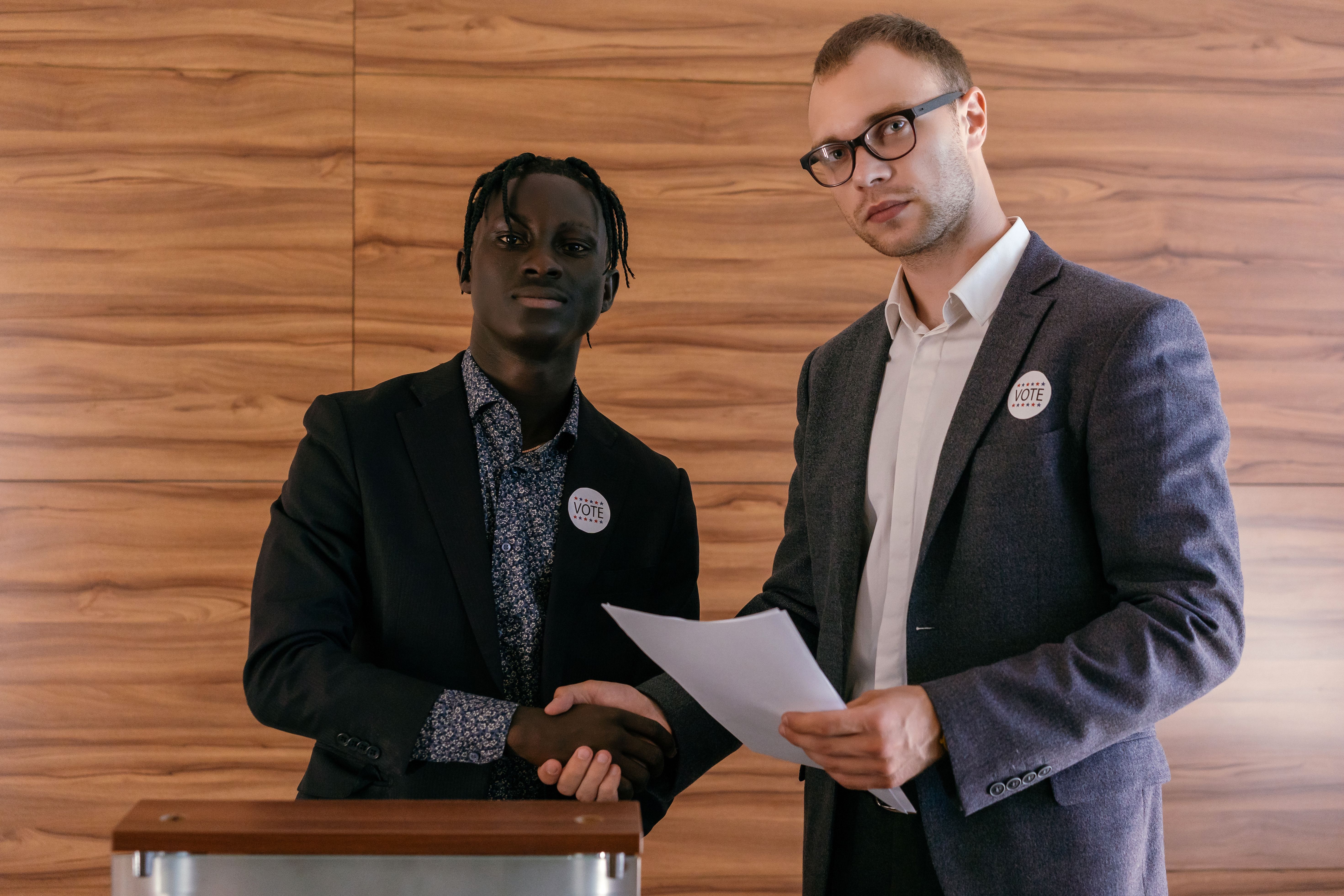 Two men in business attire shaking hands, symbolizing coalition alliances and political agreements