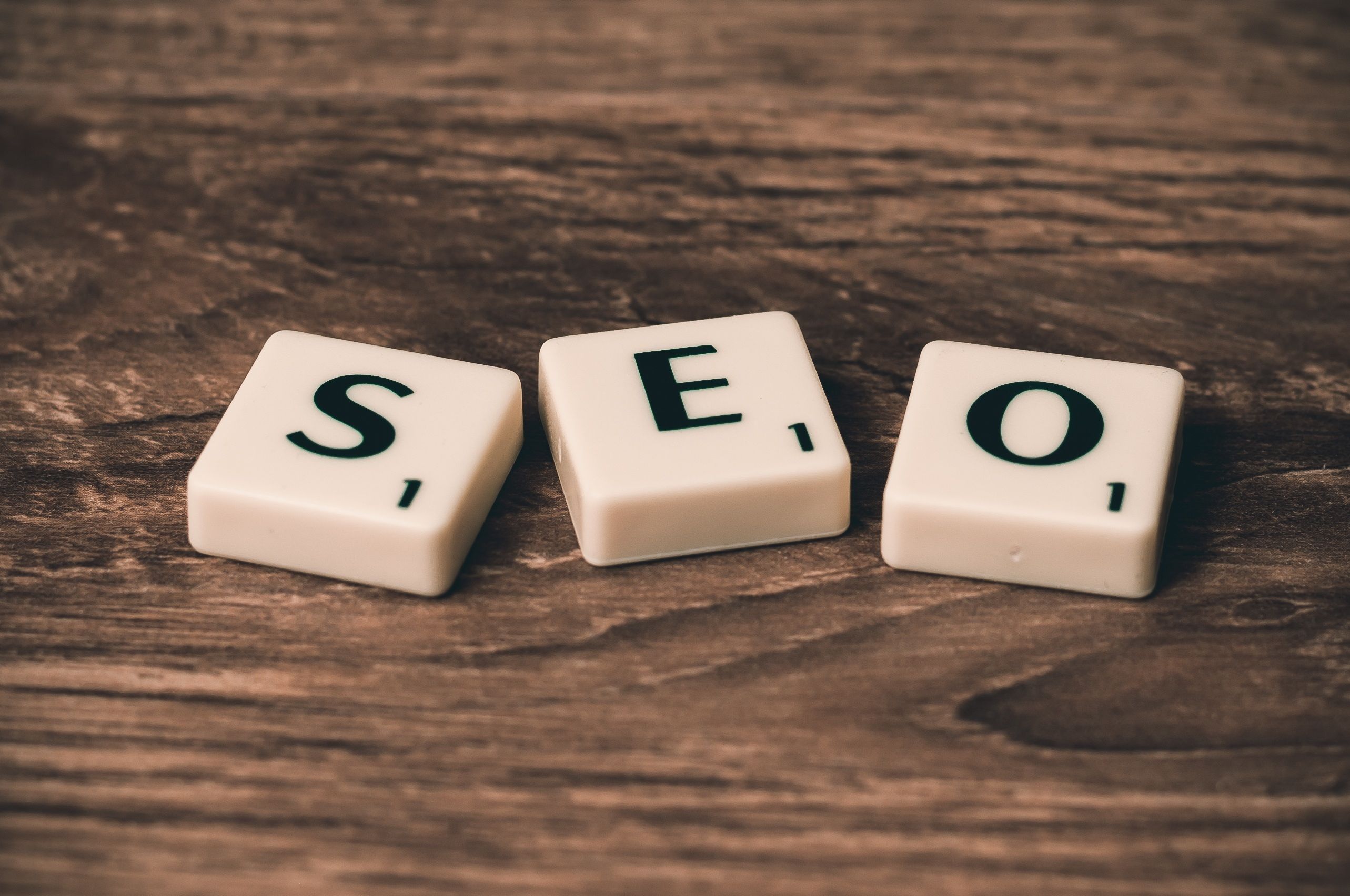 Scrabble tiles spelling SEO on a wooden surface representing WordPress search engine optimization