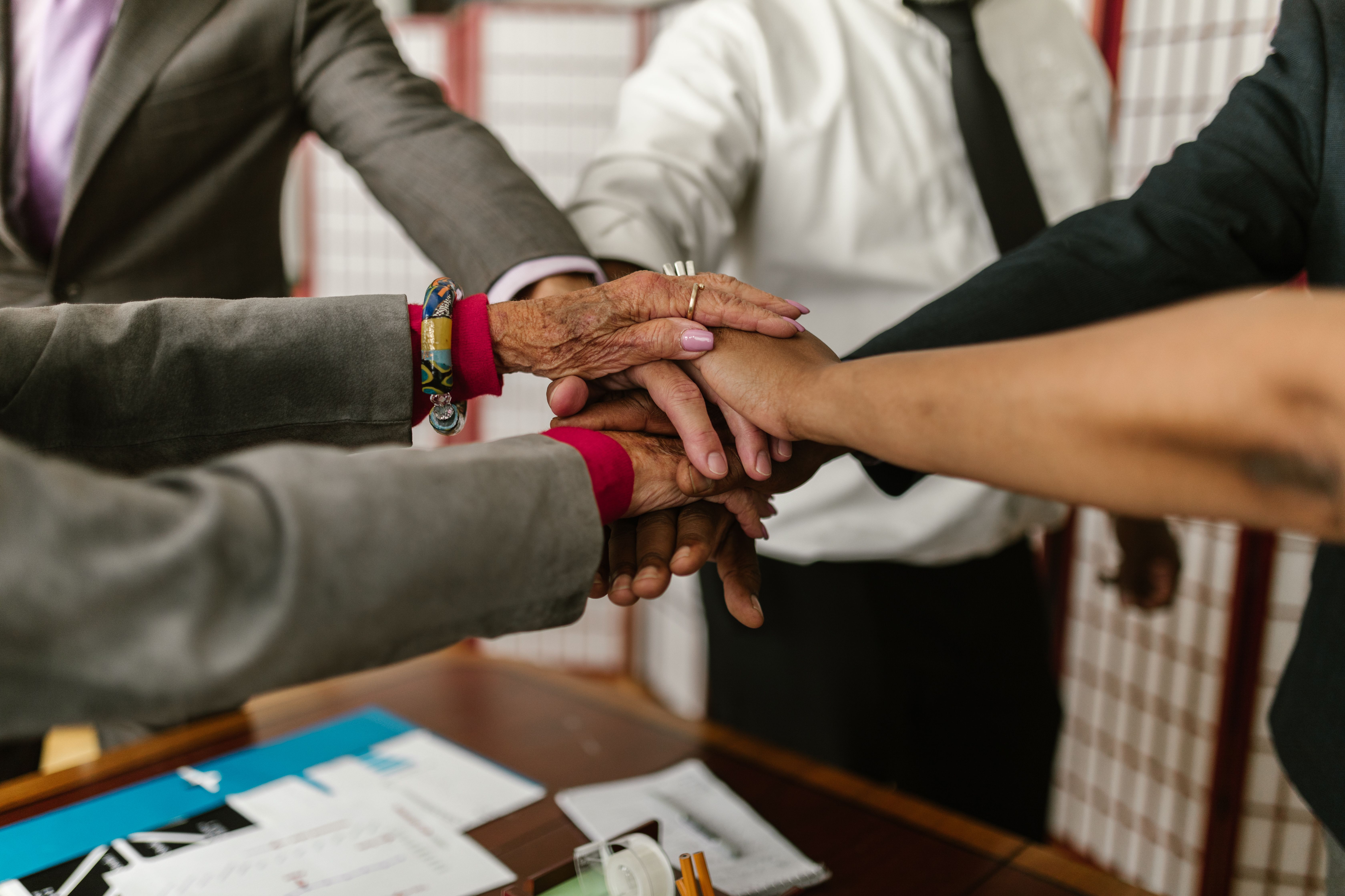 Diverse businesspeople uniting their hands to symbolize teamwork and shared accountability