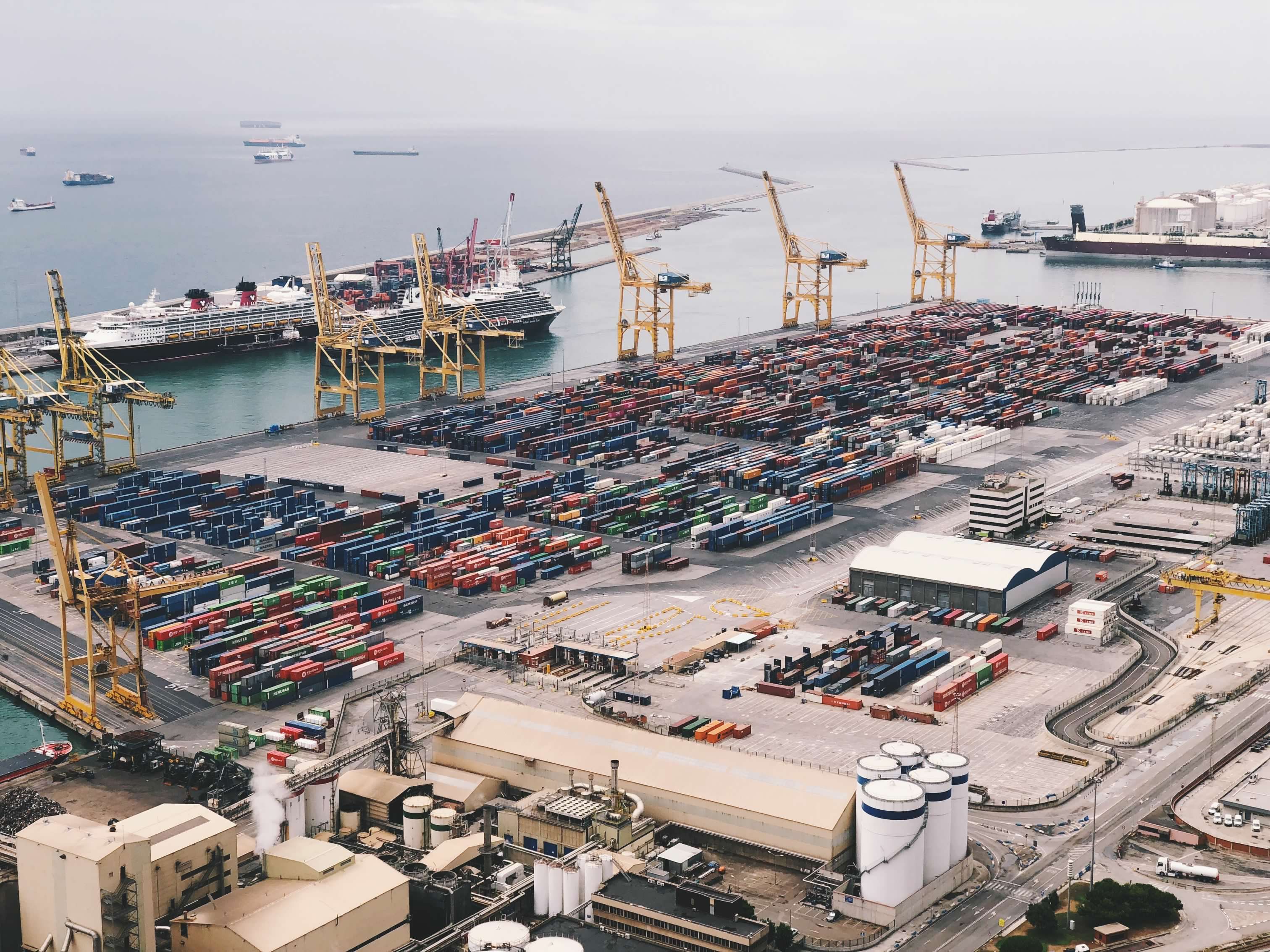 Aerial view of a busy container port with cranes and cargo ships representing international trade